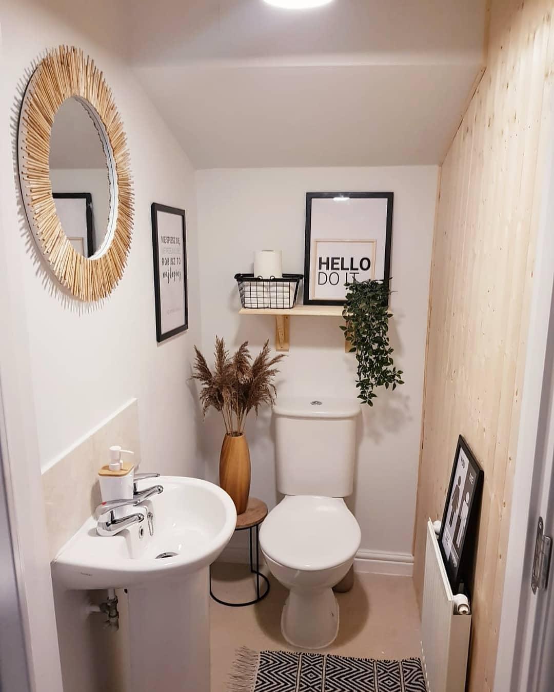 Toilettes blanches avec un mur en bois clair et des cadres noirs et un miroir mural