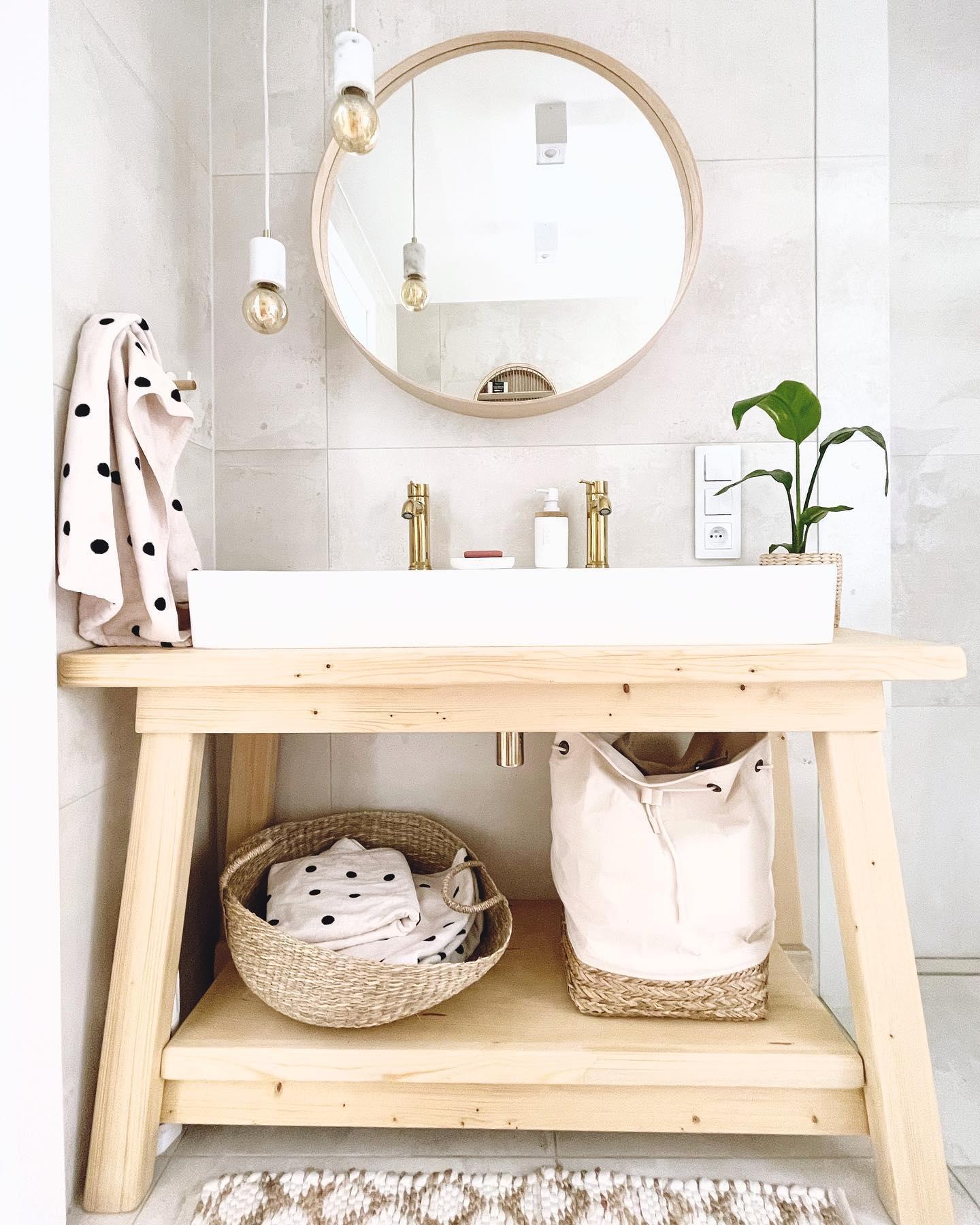 toilettes avec meuble de vasque en bois clair et des paniers de rangements en tissus et en osier