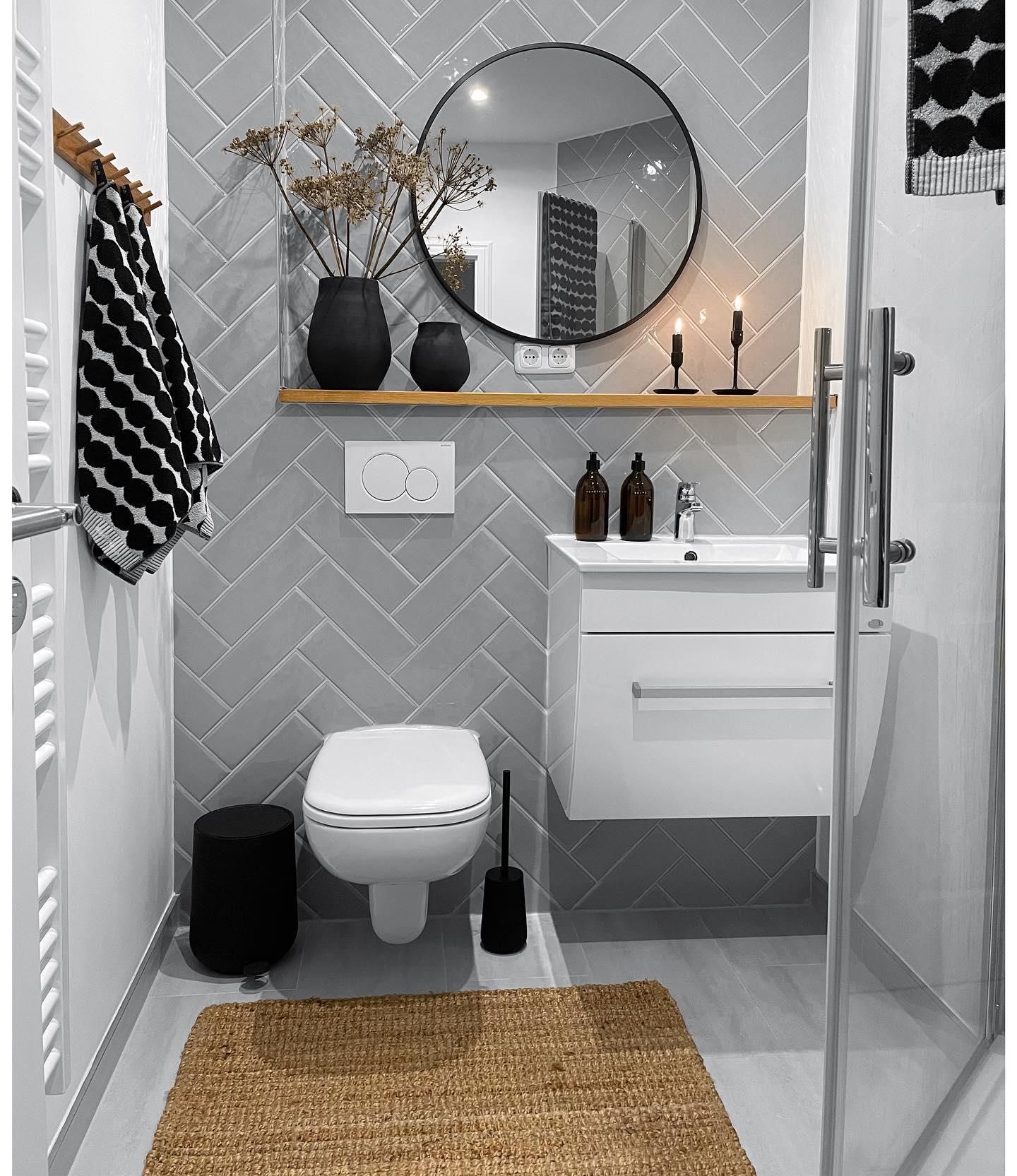 toilettes blanches et grises avec des accessoires de déco noirs