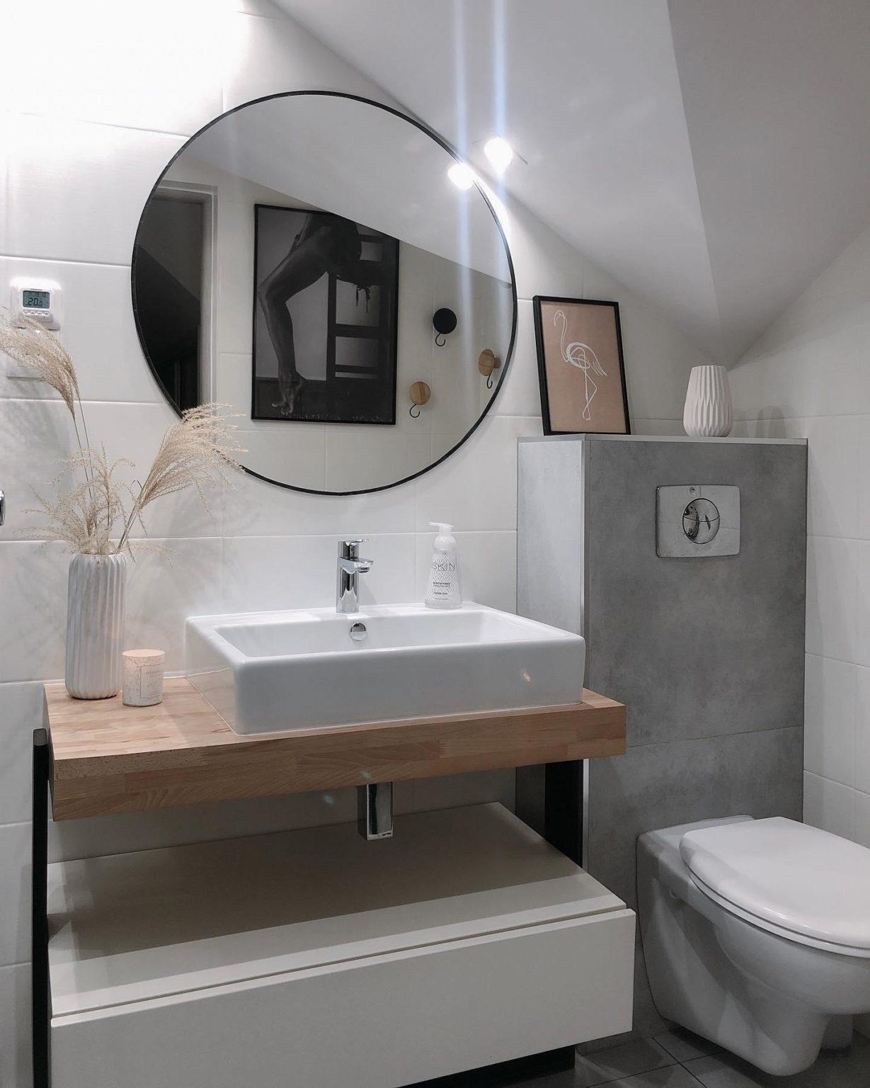 toilettes suspendues avec du carrelage gris et un meuble de vasque de bois