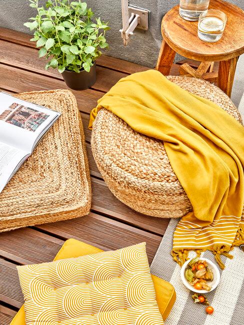 terasse avec coussin de sol jaune et accessoires en osier