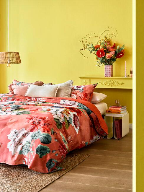 chambre jaune avec des draps de lits dans les tons rose avec des fleurs