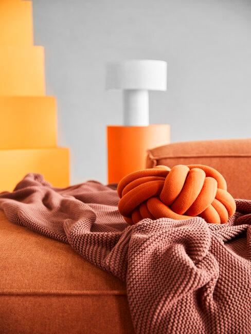 canapé orange avec coussin et plaid orange