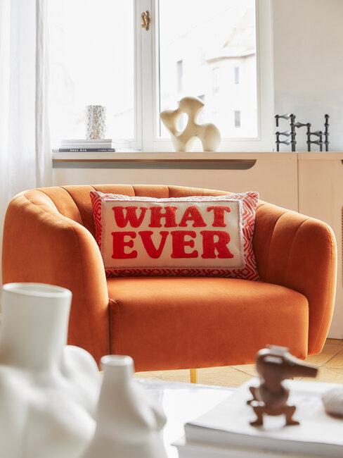fauteuil orange avec coussin blanc et orange dans un salon blanc