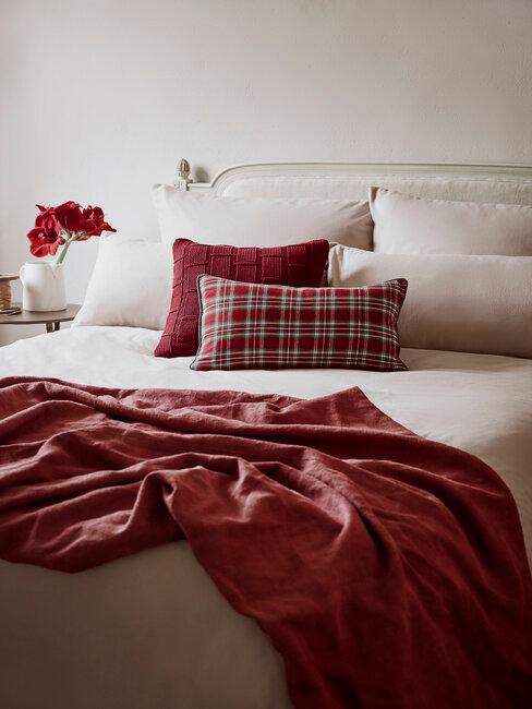 lit beige avec plaid et coussins rouge bordeaux