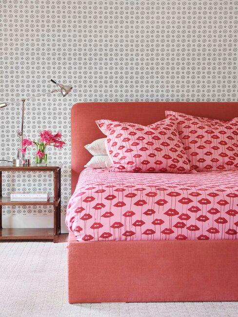 chambre avec lit rouge et draps de lits rose et rouge