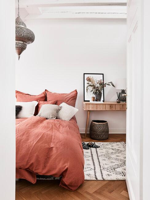 chambre blanche avec draps de lit rouge brique