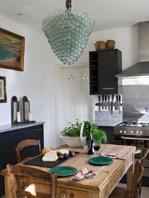 cuisine avec table à mager et un lustre et de la décoration de table verte