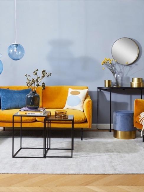 salon bleu avec canapé jaune moutarde, pouf bleu et doré