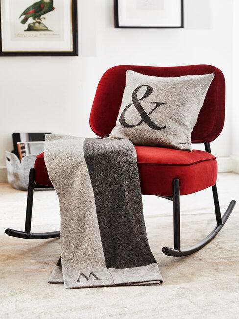 fauteuil rouge avec coussin et plaid gris