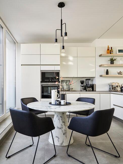 cuisine blanche avec table à manger en marbre et des fauteuils noirs