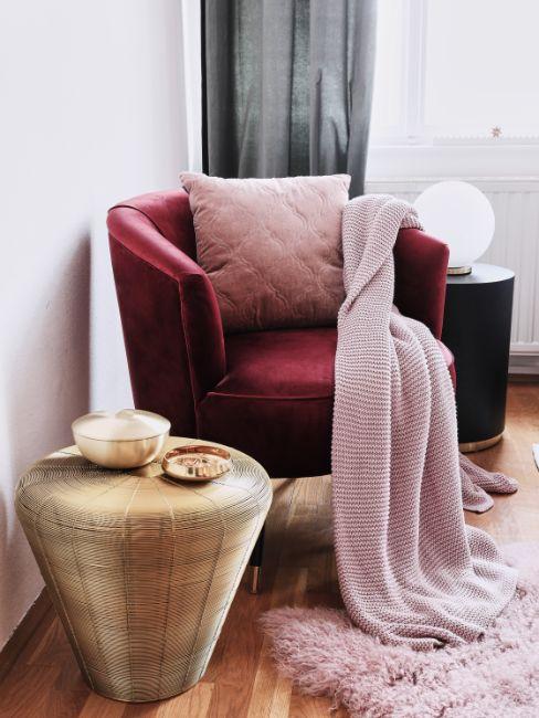 fauteuil en velours de couleur rouge bordeaux, table d'appoint dorée