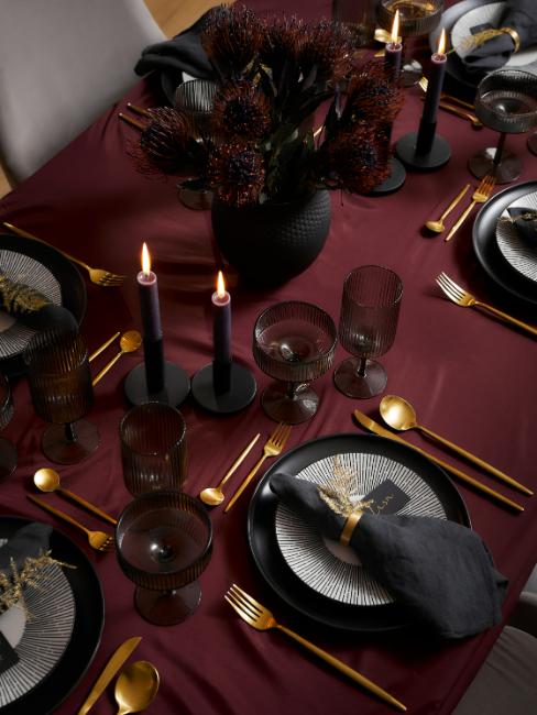 déco de table réveillon, nappe bordeaux, couverts dorés, assiettes noires