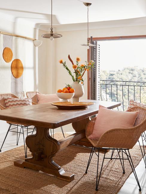 salle à manger style estival, coussins couleur pêche, tapis en jute, chaises en rotin