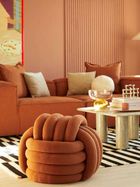 salon avec pouf et canapé terracotta, mur terracotta clair