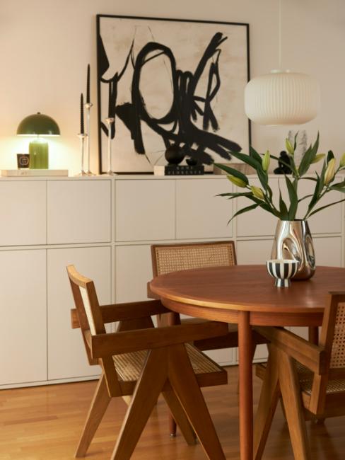 tableau abstrait noir et blanc posé sur la commode d'une salle à manger design