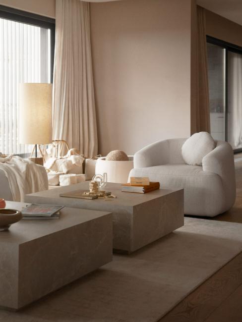 coin salon avec fauteuil et canapé blancs et table basse effet marbre