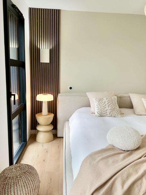 applique murale au-dessus d'une lampe de chevet dans une chambre scandinave