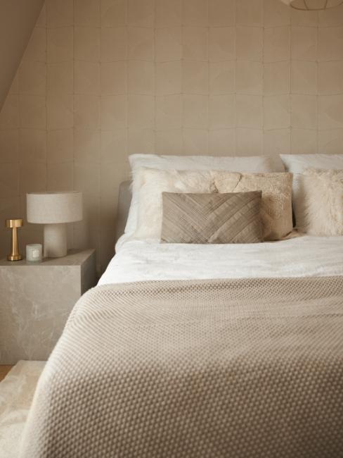 lit avec couvre-lit en tricot et rangées de coussins