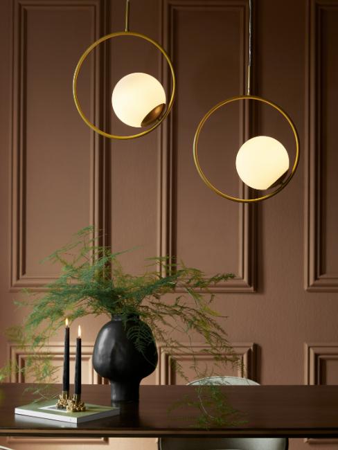 salle à manger avec peinture tendance 2025 marron terreux et suspensions dorées