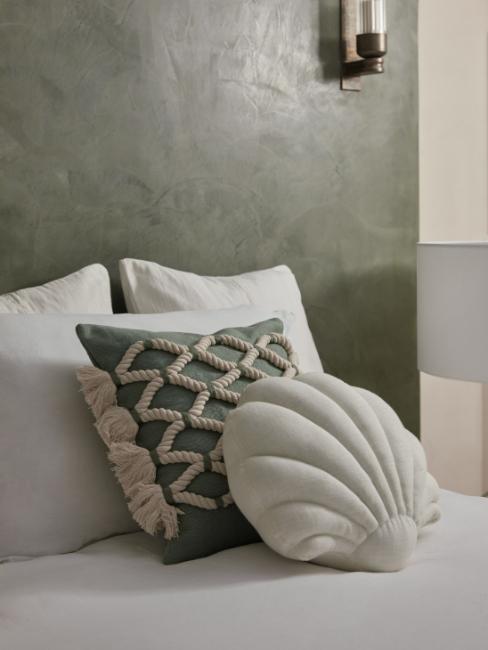 coussins décoratifs avec cordages et en forme de coquillages sur un lit