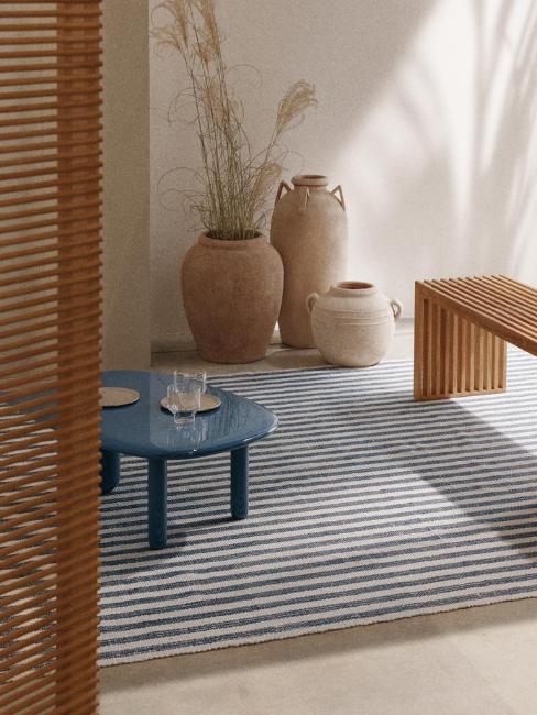 salon style bord de mer avec tapis rayé bleu et blanc et vases vieillis