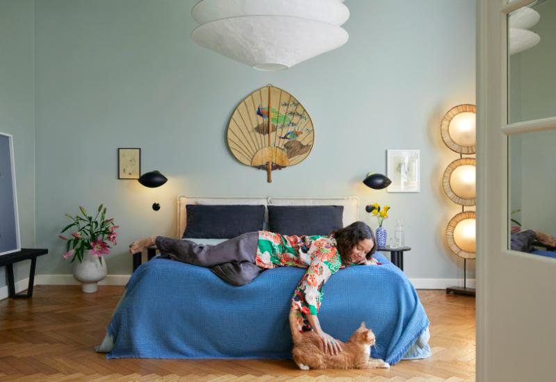 chambre ado bleue avec fille allongée sur lit et chat