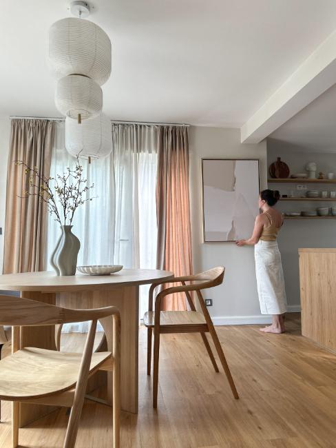 femme posant un cadre dans salle à manger style japandi