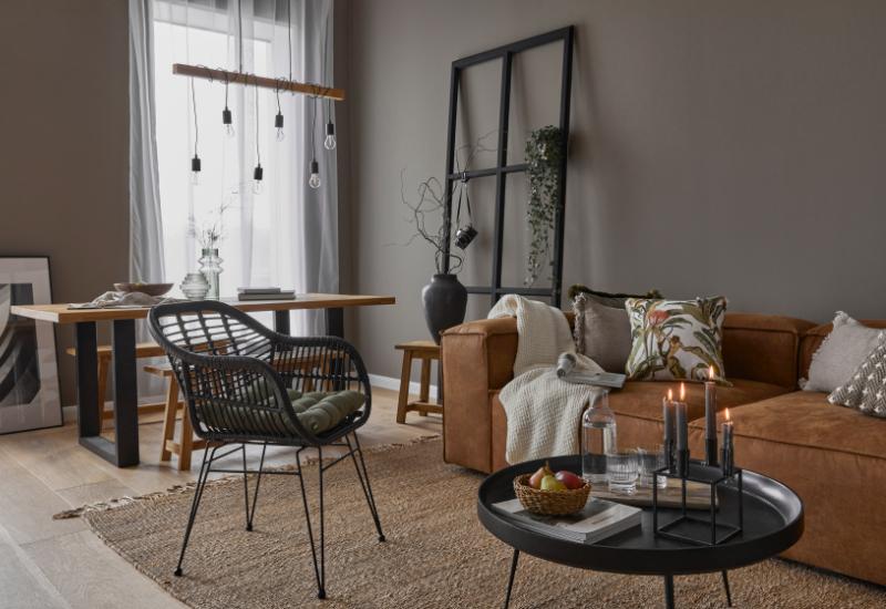 salon industriel cocooning avec plaid en tricot et coussins et canapé cuir recyclé