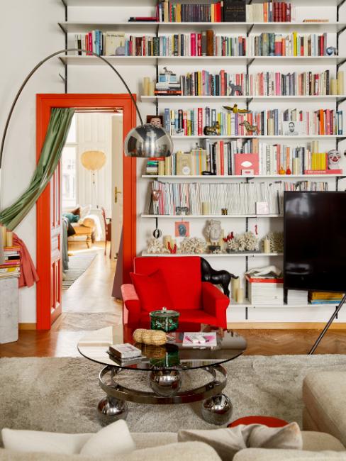 Déco salon vintage avec nombreux livres aux étagères et fauteuil rouge