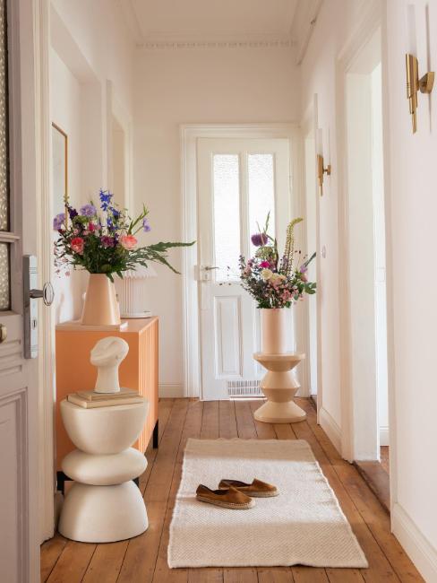 décoration d'une entrée avec table d'appoint et vases ornés de grands bouquets