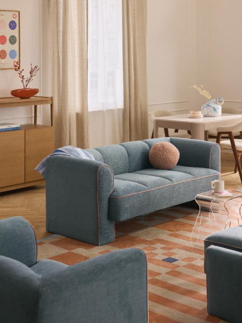 petit canapé arrondi bleu avec coussin boule rose