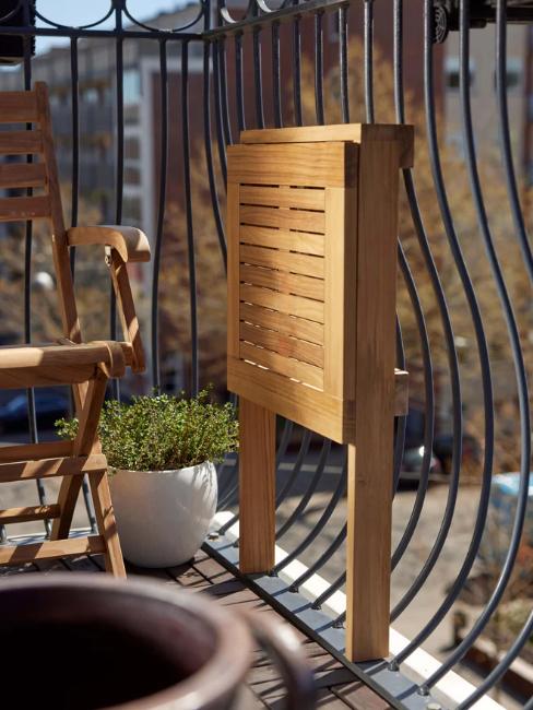 table pour balcon étroit pliante en bois repliée et fixée au garde corps