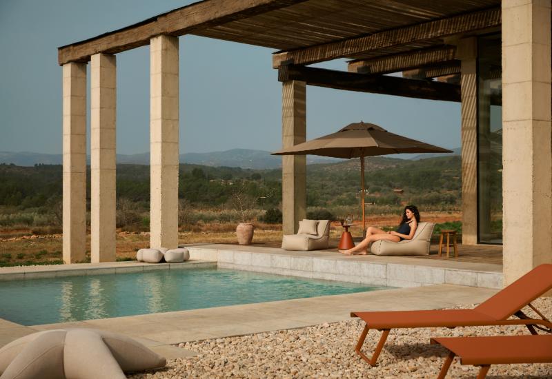 grande terrasse couverte en canisses avec piliers en béton et piscine