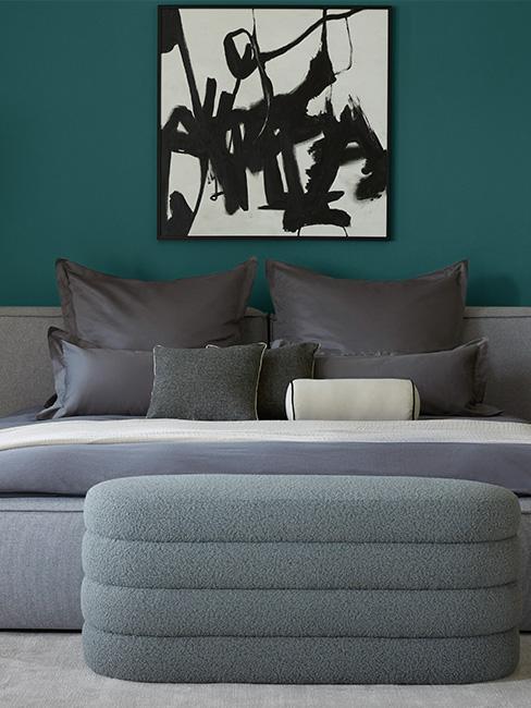 chambre avec mur peint en bleu canard, lit et banc gris
