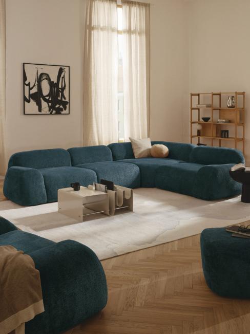 grand canapé d'angle et fauteuils bleu canard dans salon blanc crème