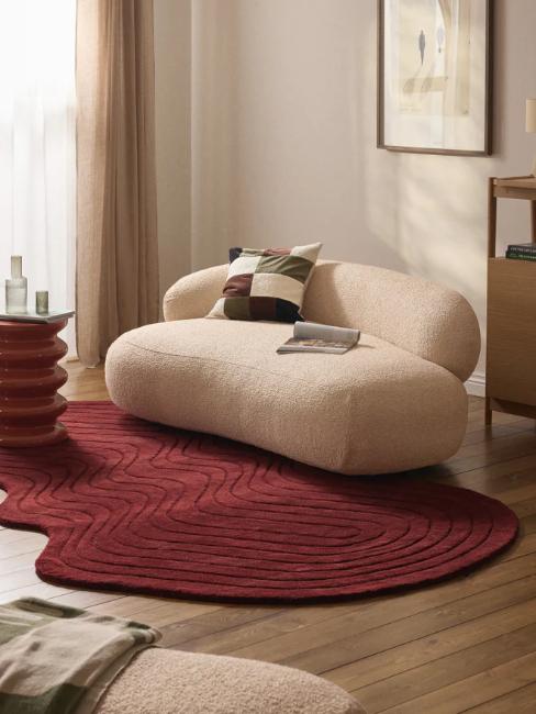 canapé arrondi beige et tapis organique rouge bordeaux