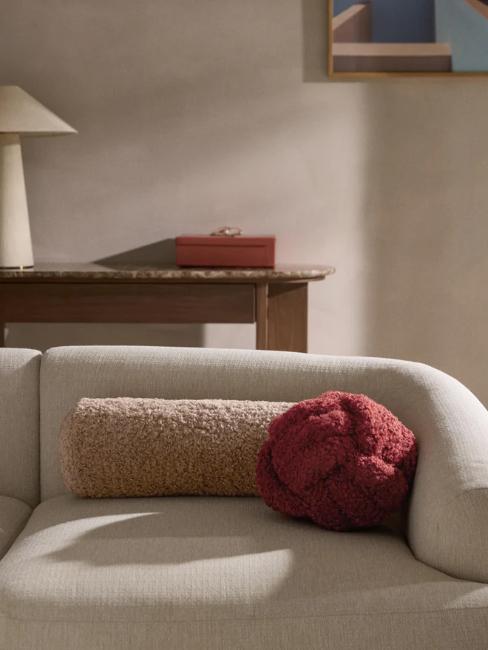 coussin nœud rouge bordeaux sur canapé arrondi blanc