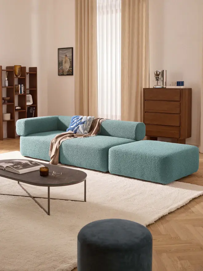 méridienne turquoise dans un salon beige avec meubles en bois foncé