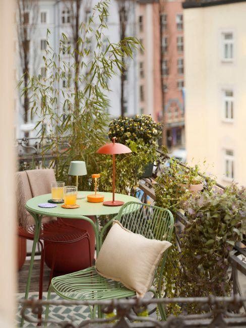 mali balkon sa šarenim stolom i stolicama