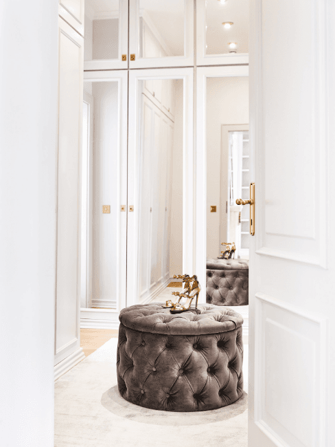 Spogliatoio con armadi a specchio e pouf al centro