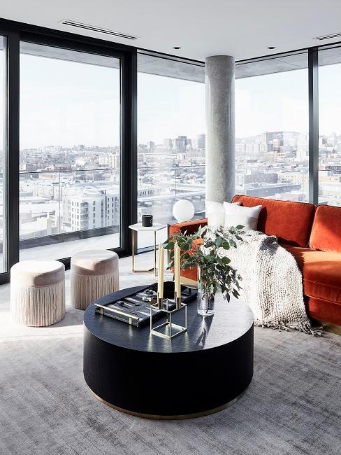 Soggiorno di design in un attico a Montreal con un grande tavolino, un divano e due sgabelli a frange.