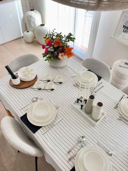 tavola primaverile con tovaglia a righe e vaso di fiori