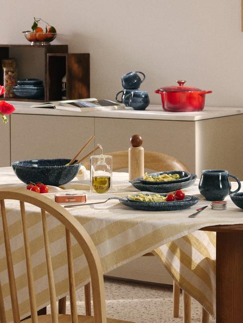 tavola con tovaglia a righe e piatti blu