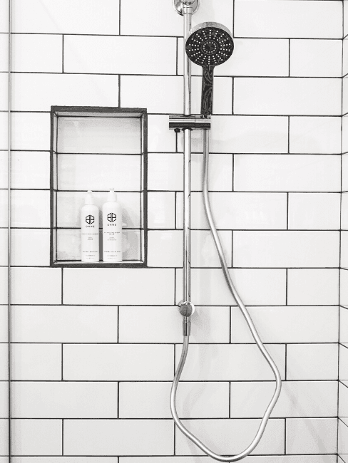 Dettaglio doccia con piastrelle bianche