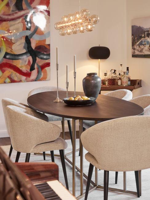 tavolo da pranzo ovale in legno e poltroncine chiare