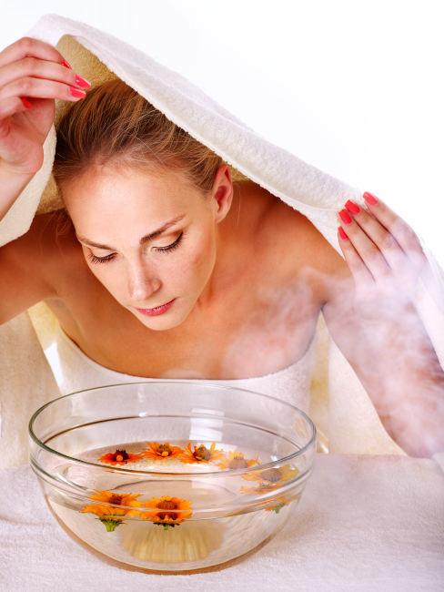 Donna che fa un bagno di vapore al viso