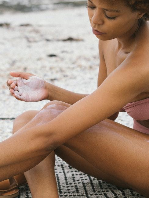 ragazza che si spalma crema solare