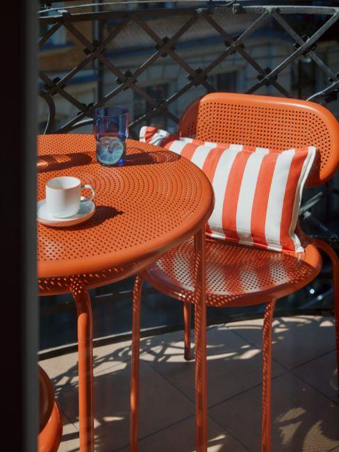 tavolino e sedie rosse su balcone mini