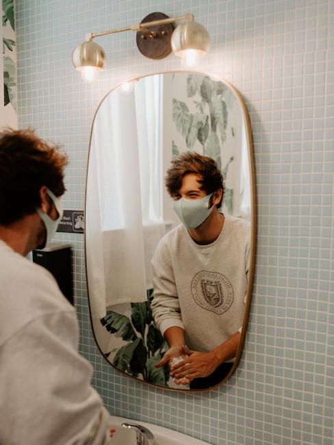 ragazzo con mascherina che si guarda allo specchio